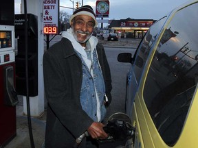 Mohammed Aman is all smiles while filling up at Windsor Variety and Gas on University Avenue West December 8, 2014.  (NICK BRANCACCIO/The Windsor Star)