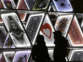 A couple looks at a light sculpture called, "House of Cards," by OGE Creative Group, from Israel, near Central Station in Amsterdam.