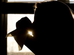 A woman is silhouetted as she uses a tissue to blow her nose in Toronto on Friday, November 21, 2014. With cold and flu season looming, snot - or nasal mucus, as it can be more delicately described - is something many of us will experience first hand in the not-too-distant future.
Photograph by: Nathan Denette , The Canadian Press