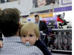 Industry Minister James Moore, rear, makes an announcement in a toy store in Toronto on Dec. 9, 2014. Moore announced legislation aimed at ensuring prices in Canada are not unfairly higher than those in the U.S.
(Colin Perkel/The Canadian Press)