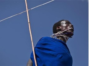 A Maasai warrior catches his swinging necklace with his mouth as he makes the high jump, in which athletes must touch a high line with the top of their heads, at the annual Maasai Olympics in the Sidai Oleng Wildlife Sanctuary near to Mt Kilimanjaro, in southern Kenya Saturday, Dec. 13, 2014. (Ben Curtis/The Associated Press)