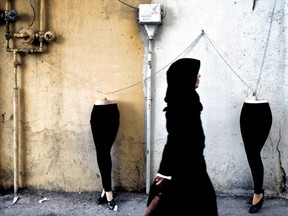 An Iranian woman walks past mannequins locked to a gas pipe in northern Tehran on December 15, 2014. AFP PHOTO/BEHROUZ MEHRIBEHROUZ MEHRI/AFP/Getty Images