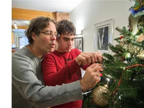 Eric Houde, left, and his son Benji Cukier-Houde, who is autistic, decorate their Christmas tree at their home in Montreal on Saturday, December 6, 2014. (Dario Ayala / Montreal Gazette)