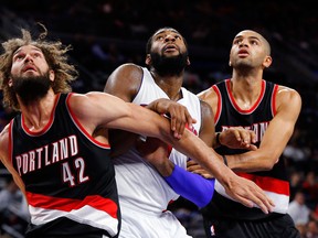 Portland's Robin Lopez, left, and Nicolas Batum, right, block out Detroit's Andre Drummond in the second half Tuesday in Auburn Hills, Mich. (AP Photo/Paul Sancya)