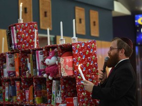 Rabbi Sholom Galperin sings Chanukah songs after candles were lit on a toy-filled menorah during Chanukah celebrations sponsored by Chabad Jewish Centre at Devonshire Mall Wednesday December 17, 2014. Hundreds of toys are donated to Children's Aid Foundation and Mayor Drew Dilkens was honoured by lighting the first candle. (NICK BRANCACCIO/The Windsor Star)