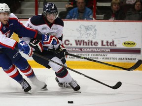 Windsor's Logan Stanley, left, checks Kris Bennett of Saginaw Spirit Thursday at the WFCU Centre. (NICK BRANCACCIO/The Windsor Star)