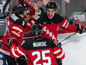 Canada's Max Domi, right, celebrates his goal with Shea Theodore, left, and Darnell Nurse during the second period Wednesday at the IIHF World Junior Championship in Montreal. (THE CANADIAN PRESS/Paul Chiasson)