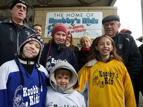 Knobby's Kids, front row from left, Noah Villeneuve, 9, Caleb Villeneuve, 7, Zoe Villeneuve, 10, and Benjamin Villeneuve, 7, centre are joined by Knobby's Kids co-founders, Frank Spry, far left, and Jerry Slavik, far right, as well as St. Clair College Alumni Association board members at Lanspeary Park, Monday, Dec. 1, 2014. Knobby's Kids received a $5000 cheque from the St. Clair College Alumni Association to cover ice time costs and insurance for the season. (DAX MELMER/The Windsor Star)