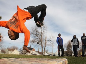Sam Byamugu, 13, does a backflip onto an old mattress while his friends watch at Fred Thomas Park on a balmy Monday, Dec. 21, 2014. (DAX MELMER/The Windsor Star)
