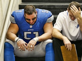 Detroit centre Dominic Raiola, left, sits on the steps after the Lions lost in overtime to the New York Giants at Ford Field last year. (Photo by Leon Halip/Getty Images)