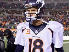 Denver quarterback Peyton Manning walks off the field following a 37-28 loss in Cincinnati. (AP Photo/Michael Conroy)