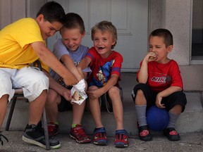With the last mint chocolate cookie gone, C.J. Cavanaugh, 10, left, fights for the crumbs with Michael Liles, 8, Cooper Liles, 6, as Ayden Cavanaugh, 5, right, calmly enjoys his treat on Ottawa Street Wednesday June 25, 2014. NICK BRANCACCIO/The Windsor Star)