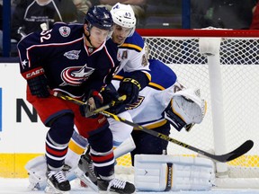 Tecumseh's Kerby Rychel, left, is checked by St. Louis' Maxim Lapierre in a pre-season game in Columbus. (AP Photo/Paul Vernon)