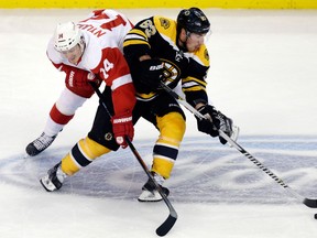 Boston's Brad Marchand, right, is checked by Detroit's Gustav Nyquist Monday in Boston. (AP Photo/Charles Krupa)