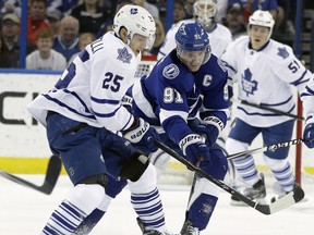 Tampa Bay's Steven Stamkos, centre, is checked by Toronto's Mike Santorelli Monday in Tampa. (AP Photo/Chris O'Meara)