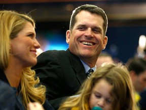 Jim Harbaugh, right, looks on with his wife Sarah as he is introduced as the new head coach of the University of Michigan football team at the Junge Family Champions Center Tuesday in Ann Arbor. (Photo by Gregory Shamus/Getty Images)