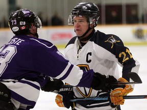 Windsor's Drew Palmer, right, glares at Western's Kyle De Coste after Palmer took a couple of cross checks behind the play at South Windsor Arena. (NICK BRANCACCIO/The Windsor Star)