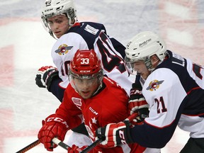 Windsor's Ryan Moore, left, and Logan Brown, right, check the Soo's Gabe Guertler at the  WFCU Centre Thursday. (NICK BRANCACCIO/The Windsor Star)