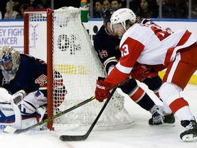 New York goalie Henrik Lundqvist, left, makes a save on Detroit's Darren Helm in New York.  (AP Photo/Frank Franklin II)