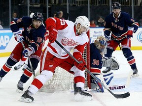 Detroit's Brian Lashoff, centre, is checked by New York's Derick Brassard in front of goalie Henrik Lundqvist at Madison Square Garden. (Photo by Elsa/Getty Images)