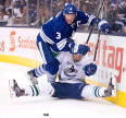 Toronto defenceman Dion Phaneuf, left, hits Canucks forward Linden Vey during the third period Saturday. (THE CANADIAN PRESS/Nathan Denette)