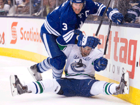 Toronto defenceman Dion Phaneuf, left, hits Canucks forward Linden Vey during the third period Saturday. (THE CANADIAN PRESS/Nathan Denette)