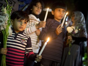 Pakistani children in Bangladesh participate in a candlelight vigil to pay tribute to the victims of Tuesday's Taliban attack on a military-run school in Peshawar, inside the Pakistani Embassy complex in Dhaka, Bangladesh, Friday, Dec. 19, 2014. The Taliban massacre killed more than 140 people, mostly children, at the school. (AP Photo/ A.M. Ahad)