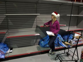 Andrea Barnett, community initiatives coordinator with the Children's Aid Society, looks over bare shelves in the organization's holiday season warehouse on Dec. 5, 2014. (Nick Brancaccio / The Windsor Star)