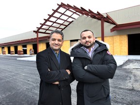 Ashok Sood and his son Anuj Sood pose in front of The City Market that is currently under construction at 1030 Walker Rd. in Windsor, ON. (DAN JANISSE/The Windsor Star)