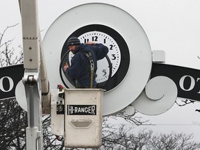 A city of Windsor worker puts the finishing touches on a decorative clock on Ottawa St. on Tuesday, Dec. 16, 2014, in Windsor, ON.   (DAN JANISSE/The Windsor Star)