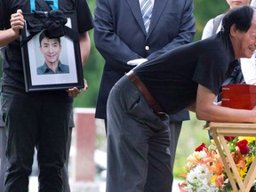 Daran Lin breaks down as he hugs the urn bearing the remains of his son, murder and dismemberment victim Jun Lin, during funeral services, July 26, 2012 in Montreal. THE CANADIAN PRESS/Paul Chiasson