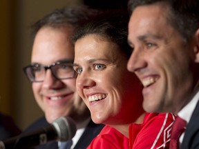 Canadian national women's team captain Christine Sinclair laughs with coach John Herdman and Organizing committee member Victor Montagliani during a FIFA news conference Friday, December 5, 2014 in Ottawa. (THE CANADIAN PRESS/Adrian Wyld)