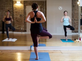 Rachael Allen, centre, an instructor at Iam Yoga, teaches a class of hot yoga in Toronto on Wednesday, December 17, 2014. THE CANADIAN PRESS/Nathan Denette