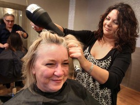 Hair stylist Barb Stewart gives Susan Strachan a cut at Salon Brush on Ottawa St. on Tuesday, Dec. 16, 2014. The staff at the salon were offering services to women who are homeless or recently homeless.  (DAN JANISSE/The Windsor Star)
