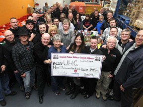 Workers with Unifor Local 444 present a cheque for $9,900 to the Unemployed Help Centre, Monday, Dec. 8, 2014.  (DAX MELMER/The Windsor Star)
