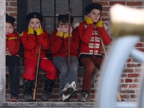 From left, Daniel Morujo, 9, Anthony Tomac, 9, Tate Hargot, 10, and Max Lombardi, 12, plug their ears while waiting for a cannon to fire during Fort Malden's Garrison Christmas event, Saturday, Dec. 20, 2014.  The young boys were dressed as soldiers from 1812.  (DAX MELMER/The Windsor Star)