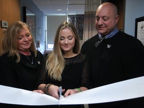 The Mamo family, from left, Annette, Bailey, 16, and Denis, cut a ribbon at the dedication ceremony for their late son Bryce Mamo, at Windsor Regional Hospital - Met Campus, Sunday, Dec. 7, 2014.  Bryce died from cancer in February 2010.  In Honour of the Ones We Love dedicated the room in honour of Bryce Mamo.  (DAX MELMER/The Windsor Star)