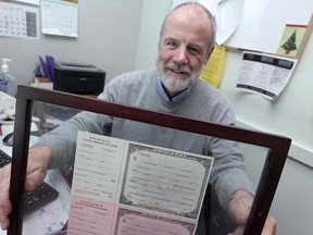 Dr. Tony Hammer holds a prescription for medicinal liquor from 1931that hangs in a glass frame in his office, Friday, Dec. 5, 2014.  Hammer said he does not believe in prescribing medicinal marijuana.  (DAX MELMER/The Windsor Star)