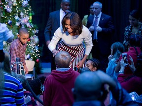 First lady Michelle Obama greets patients, families, and staff during a visit at the Children’s National Health System in Washington, Monday, Dec. 15, 2014. With the first lady is former patient, Aaron Kirby from Upper Marlboro, Md.   (AP Photo/Manuel Balce Ceneta)