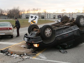 A Windsor police officer works at the scene of a two-car collision at the intersection of Jefferson Blvd. and Quality Way, Saturday, Dec. 6, 2015.  One person was taken to hospital with unknown injuries.  (DAX MELMER/The Windsor Star)