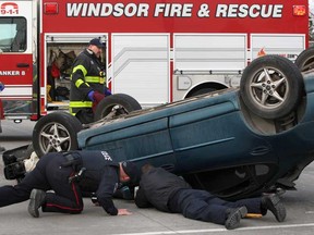 Emergency personnel work at the scene of a rollover collision on Walker Rd. and Airport Rd. Monday, Dec. 8, 2014.  (DAX MELMER/The Windsor Star)