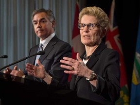 Ontario Premier Kathleen Wynne, right, and Alberta Premier Jim Prentice speak to reporters during a press conference at Queen's Park in Toronto on Wednesday, December 3, 2014. THE CANADIAN PRESS/Darren Calabrese