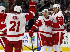 Red Wings forward Pavel Datsyuk (13) celebrates his goal with teammates Jonathan Ericsson (52), Tomas Tatar (21) and Danny DeKeyser (65) during the first period against the Carolina Hurricanes in Raleigh, N.C., Sunday, Dec. 7, 2014. The Red Wings won 3-1. (AP Photo/Karl B DeBlaker)