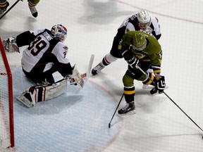 Spitfires goalie Alex Fotinos, left, keeps his eye on the puck as North Bay’s Brett McKenzie looks to take a shot during OHL
action on Saturday, Dec. 6, 2014 at the WFCU Centre. The Spits beat the Battalion 5-4. (RICK DAWES/The Windsor Star)