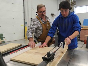 St. Annes Catholic School teacher Frank Lepain assists student, Nick Laforet  during the construction tech course on December 11, 2014.  (JASON KRYK/The Windsor Star)