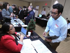 Mohammad Pavel speaks with Khush Dhindsa, left, team lead recruitment and placement at The Job Shoppe, at the Technical and Skilled Trades Career Fair at Caesars Windsor, Saturday, Dec. 6, 2014.  (DAX MELMER/The Windsor Star)