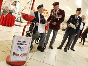 From left: Windsor-Essex veterans Raymond Pease, Bob Kelly, Bill Vivian and Frank Doolittle stand by a Salvation Army Christmas kettle in the Devonshire Mall on Dec. 23, 2014. (Tyler Brownbridge / The Windsor Star)