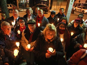 Members of the community hold a candlelight vigil outside the Aids Committee of Windsor to mark World Aids Day, Monday, Dec. 1, 2014.  Nearly two dozen people walked with candles from the Aids Committee of Windsor building to the Capitol Theatre where a ceremony was held.  (DAX MELMER/The Windsor Star)