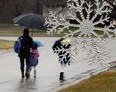 In this file photo, a winter snow ornament  hangs on a a tree as  parent and children walk in the rain near Lake Trail Drive in Windsor, Ontario on Jan. 17, 2012. (JASON KRYK/ The Windsor Star)