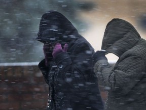 Pedestrians shield their faces from the wind in this Dec. 21, 2012 file photo. (Dan Janisse / The Windsor Star)